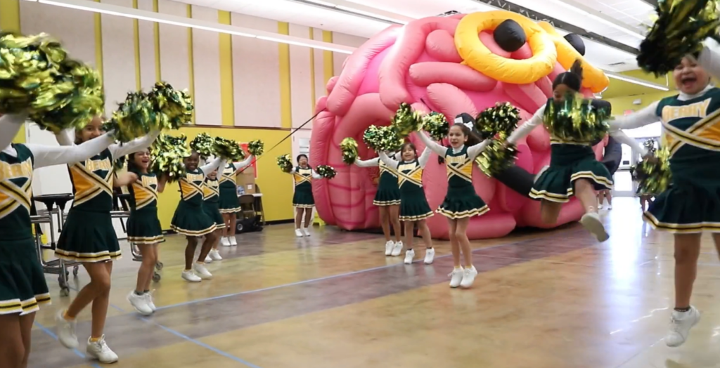 Elementary cheerleaders performing in front of the giant inflatable BrainAbouts brain